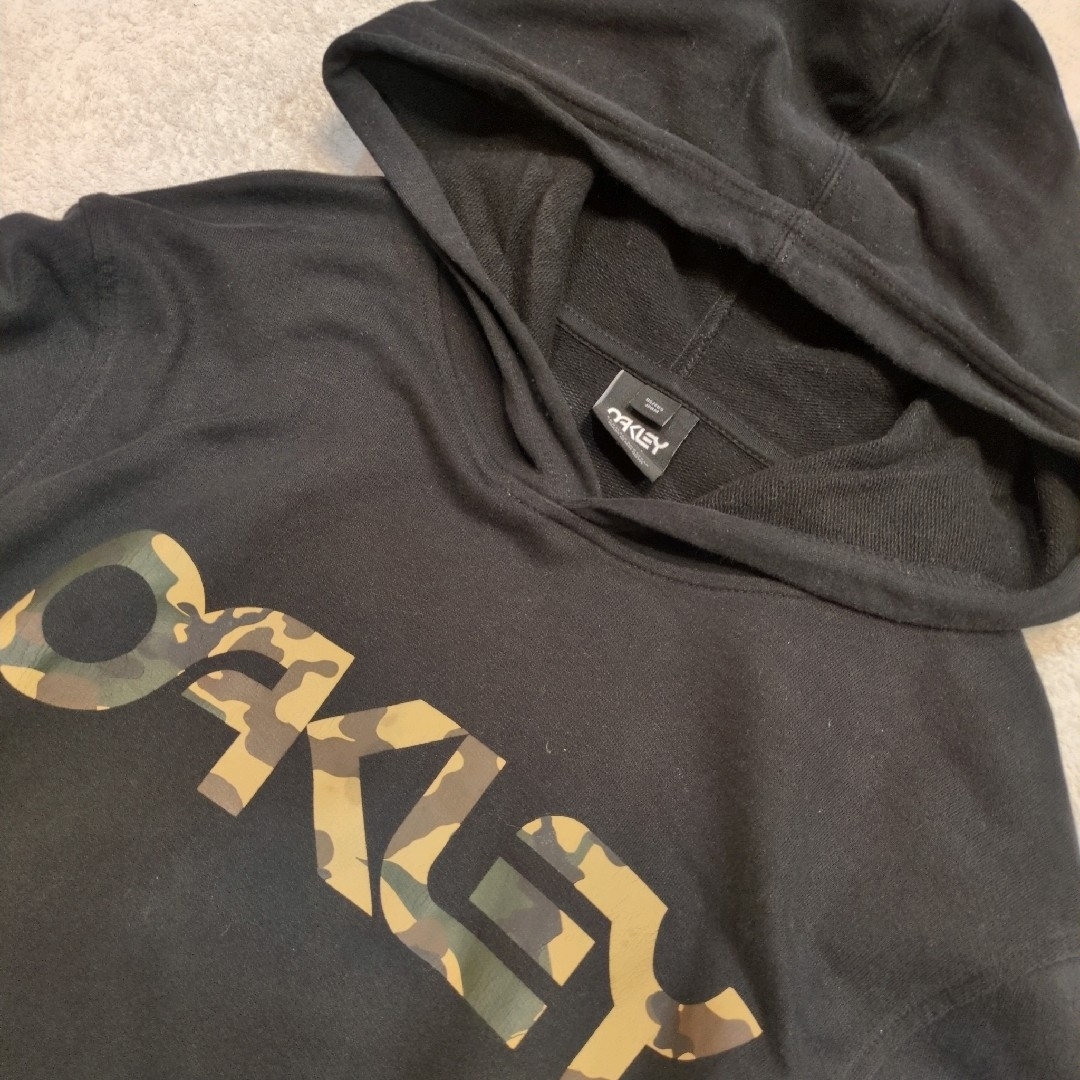 Oakley(オークリー)のオークリー 迷彩ロゴ フーディー パーカー 黒 ブラック メンズM 色落少 メンズのトップス(パーカー)の商品写真